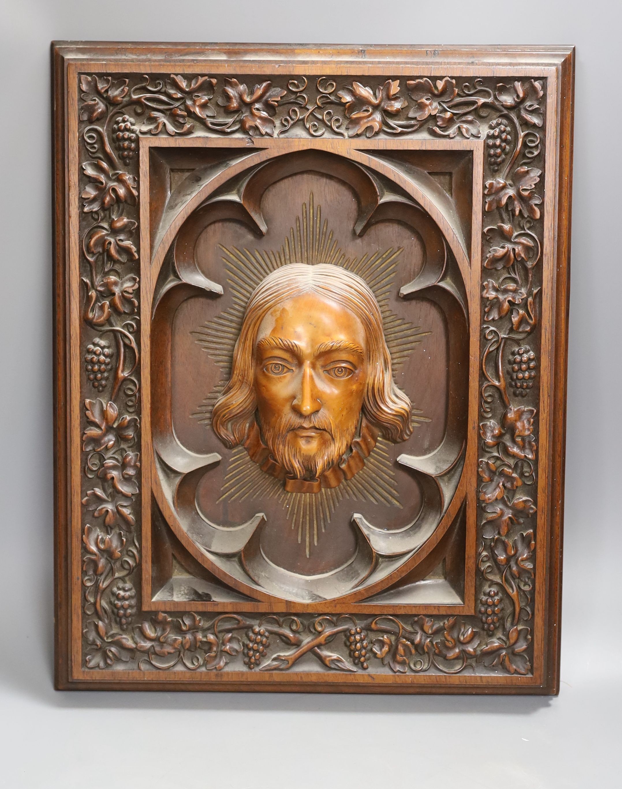 A late 19th century Continental heavily carved walnut and boxwood panel of Christ, a pair of brass lamp bases and two circular stands (5)